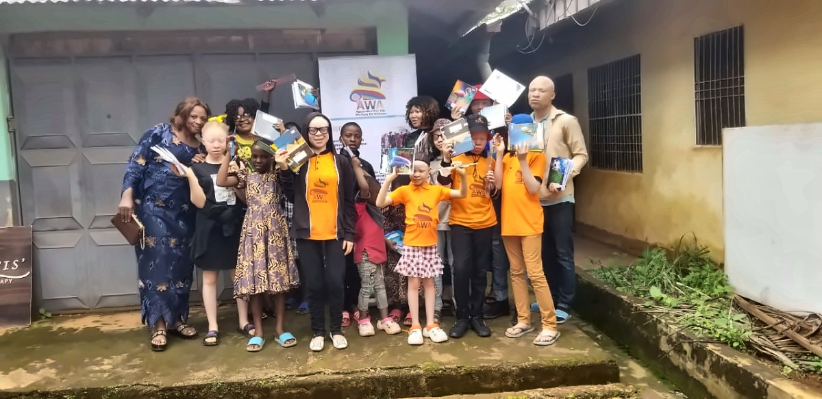 Learners with albinism holding books provided by AWA