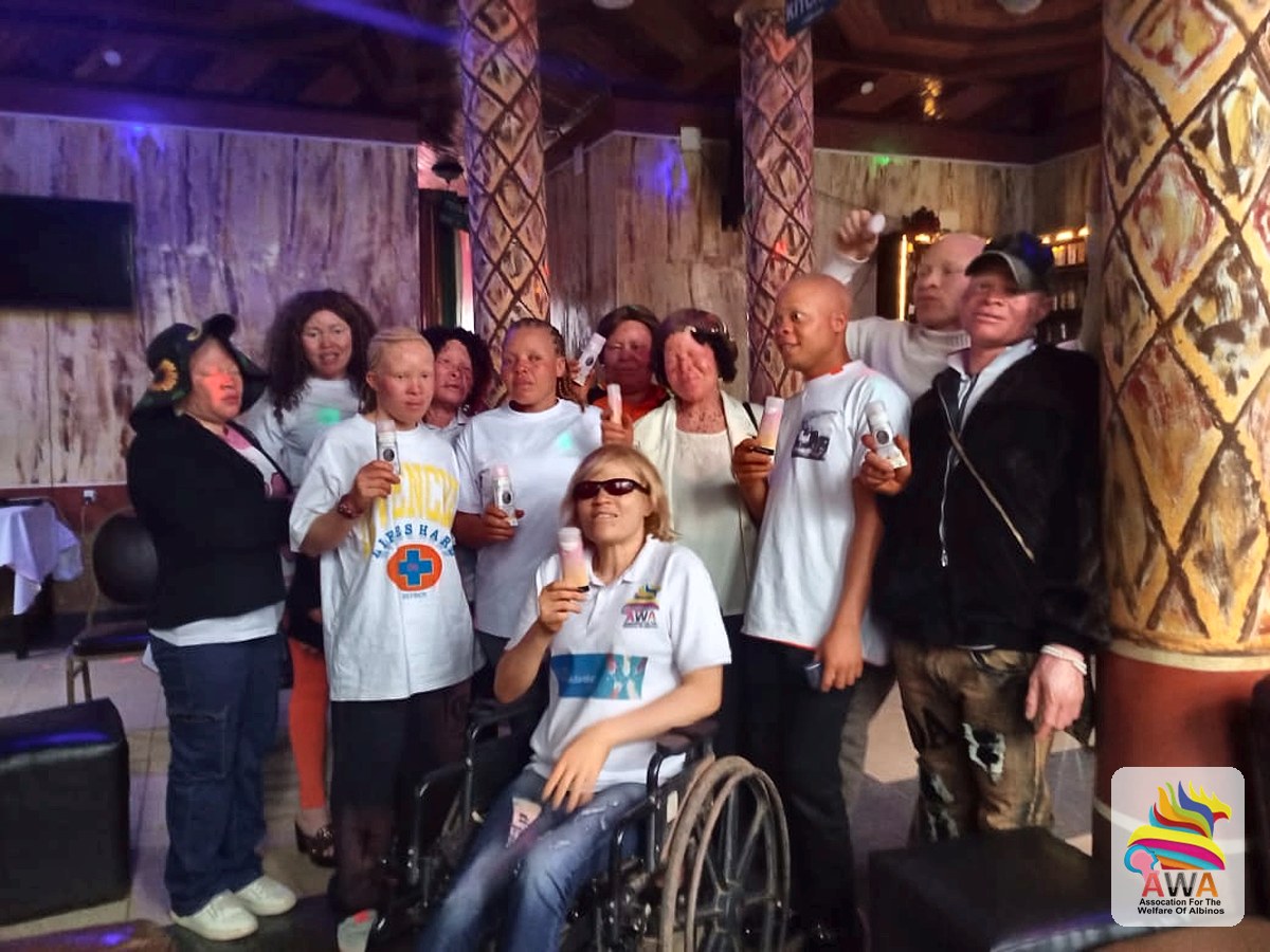 AWA members with albinism holding the sunscreen they received